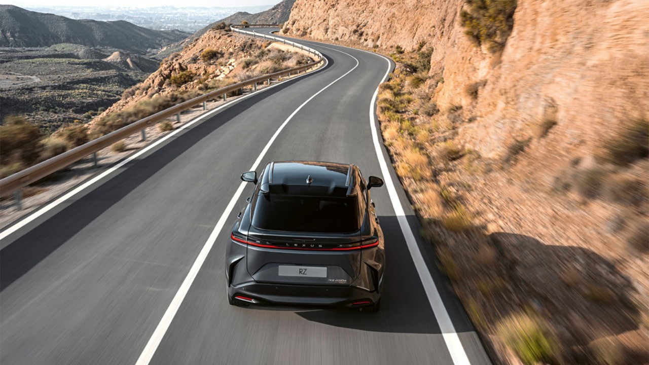 Lexus RZ driving on a hillside road