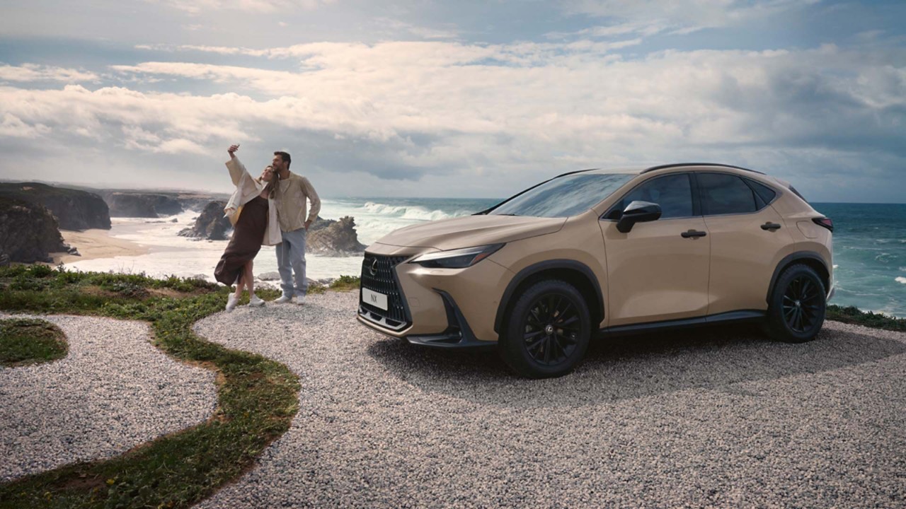 A Lexus NX parked on the coastline with two people in the background